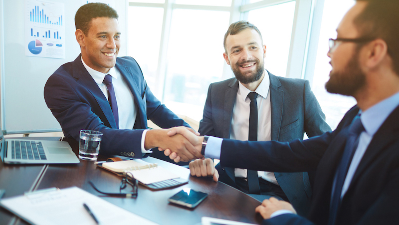 group of men in suits shaking hands