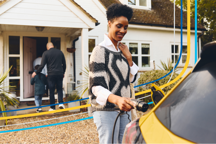 image of a woman plugging in her electric vehicle in her driveway