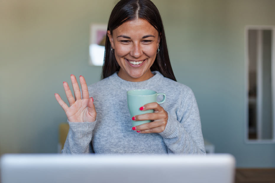 woman waving hello at laptop
