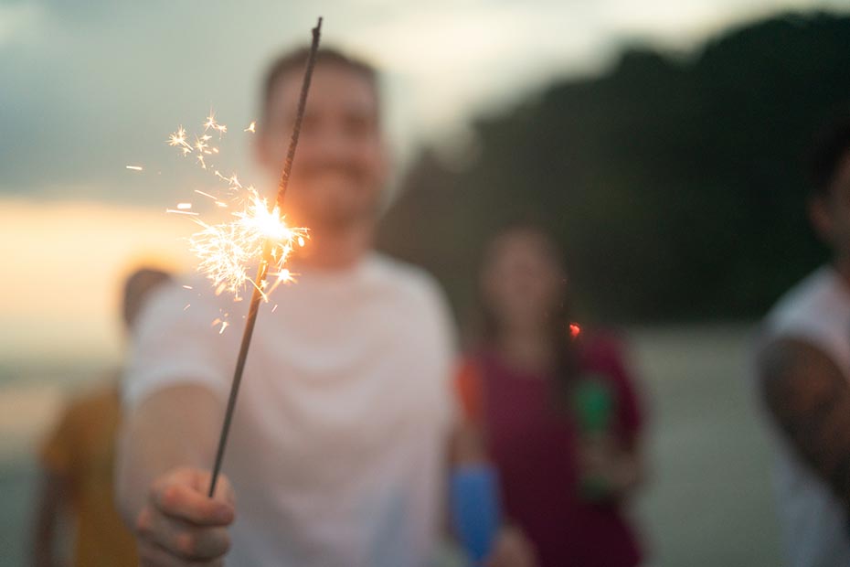 Person holding a sparkler at night.