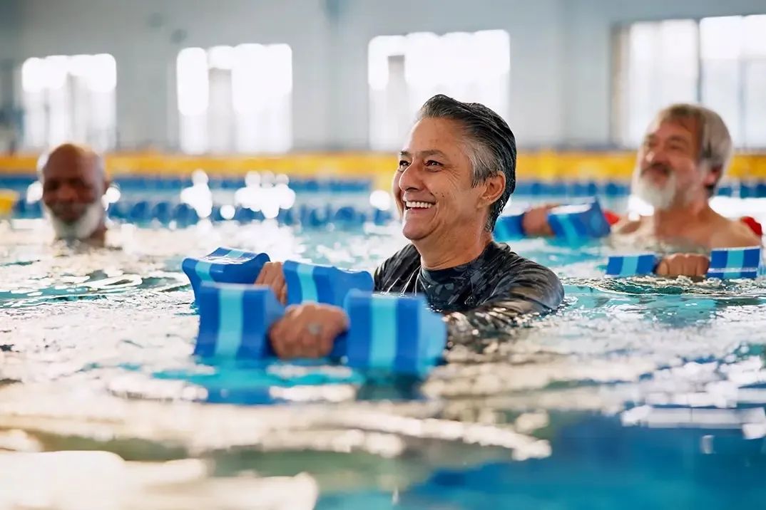Un homme âgé sourit et regarde au loin pendant son cours de natation, maintenant qu'il est couvert par une assurance-vie.