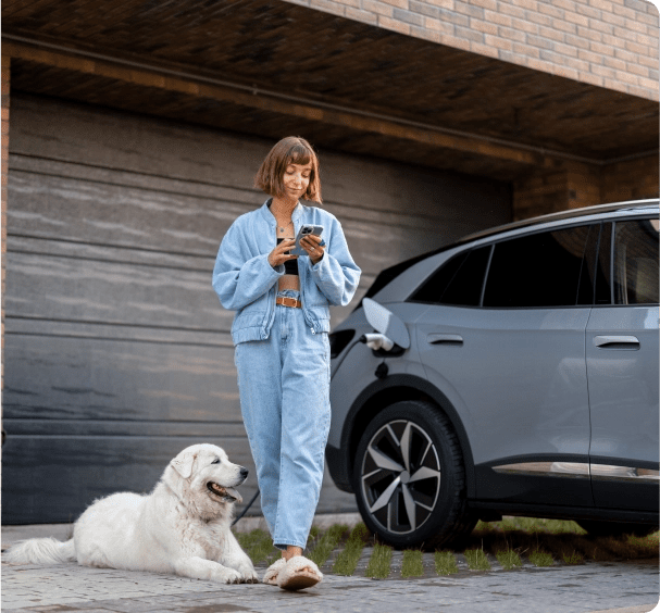 Une jeune femme recharge son véhicule électrique dans son garage