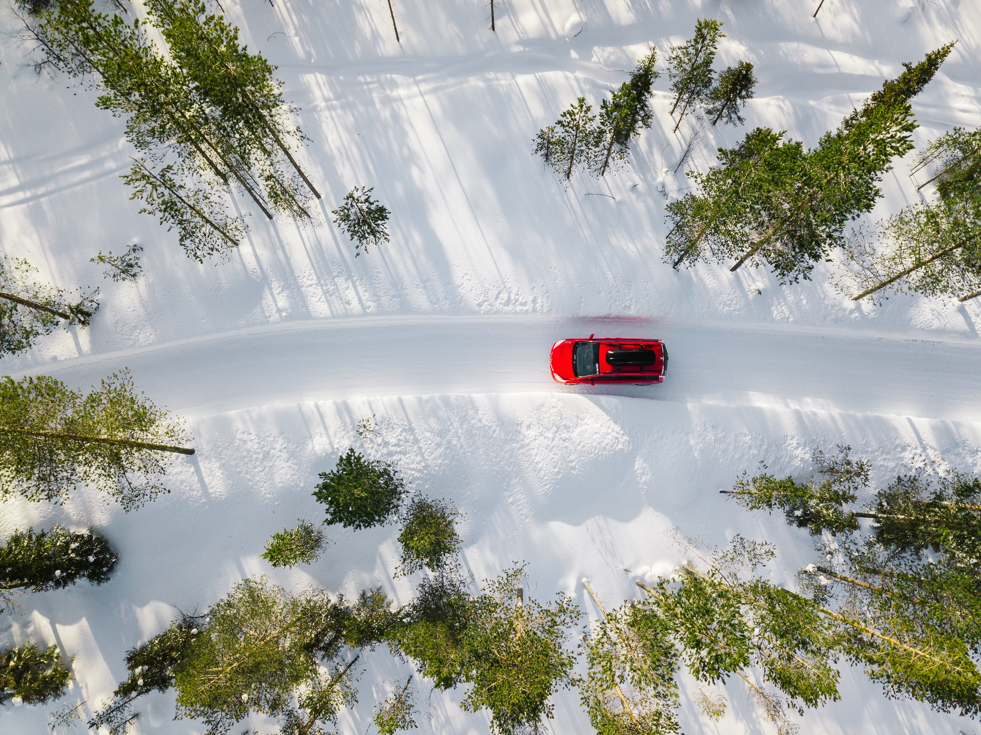 Une voiture sur les routes enneigées de l’hiver