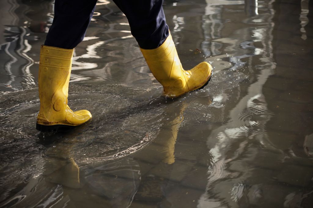 Marcher dans l’eau en portant des bottes de pluie jaunes
