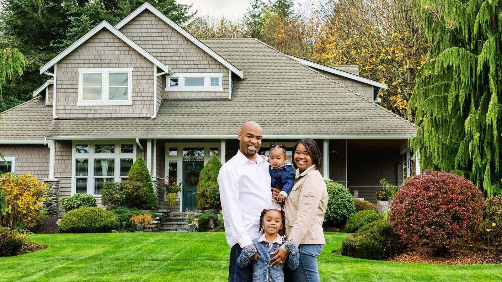 family with home in background